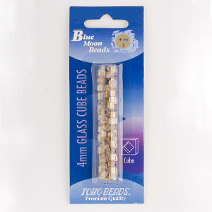 Seed bead, TOHO BEADS&reg;, glass, gold-lined clear, 4mm cube with diamond hole. Sold per 13-gram pkg, approximately 100 beads.